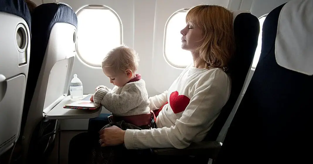 En plein vol, ils changent la couche de leur bébé parmi les passagers de l'avion-min