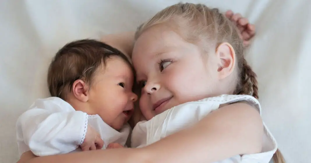 Une petite fille de 5 ans aide son nouveau-né à dormir d’une manière charmante-min